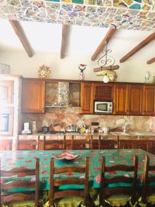 une cuisine avec une table et des chaises ainsi qu'un mur en pierre dans l'établissement Casa Vacanza Antonella, à Milazzo