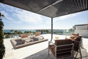 um pátio com cadeiras e um guarda-sol no telhado em Hipotels Gran Conil & Spa em Conil de la Frontera