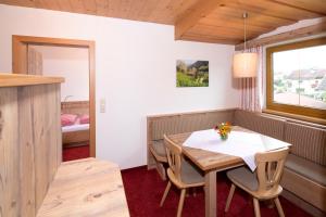 ein Esszimmer mit einem Tisch, Stühlen und einem Bett in der Unterkunft Landhaus Greil in Reith im Alpbachtal