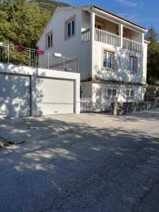 una casa blanca con una puerta de garaje blanca en Bestie House, en Kotor