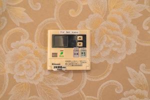 an electronic device sitting on a wall with a flower pattern at K&K Jujo House in Tokyo