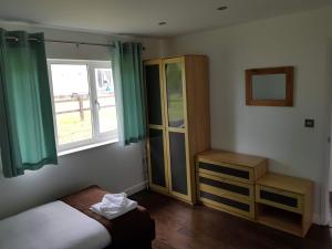 1 dormitorio con 1 cama, vestidor y ventana en Stoneleigh Village, en Sidmouth