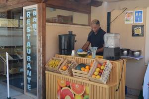 a man standing behind a counter with fruits and vegetables at Santa Brigida - Real 1 in Hontanas