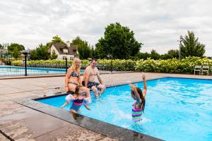un gruppo di persone sedute in piscina di TopParken – Résidence Valkenburg a Valkenburg