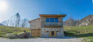 una pequeña casa con balcón en la parte superior en Albergo Diffuso Balcone sul Friuli en Clauzetto