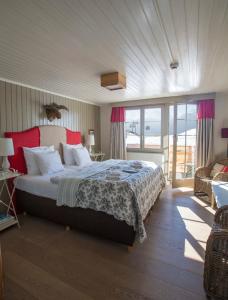 a bedroom with a large bed with red pillows at Hamilton Lodge & Spa in Belalp