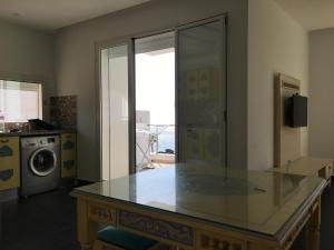 a kitchen with a glass counter top and a washing machine at Arabesque Style - 2 appartements in Kelibia