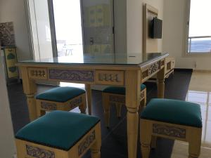 a wooden table with two stools and a mirror at Arabesque Style - 2 appartements in Kelibia