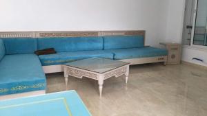 a blue couch and a coffee table in a living room at Arabesque Style - 2 appartements in Kelibia