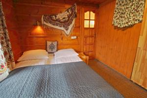 een slaapkamer met een bed in een houten hut bij Willa Długoszówka in Zakopane