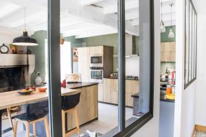 a kitchen with wooden cabinets and a large window at Varzay autour du puits in Varzay