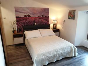 1 dormitorio con 1 cama con una pintura en la pared en Guesthouse Korzo, en Rijeka