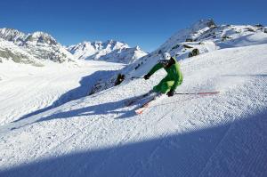 a person skiing down a snow covered slope at Hotel Alpina in Fiesch
