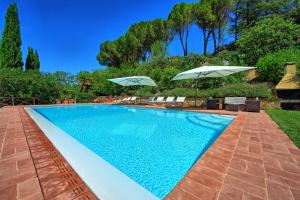 una piscina con 2 sombrillas en un patio en Villa Casa Lucia by PosarelliVillas, en Tavarnelle in Val di Pesa
