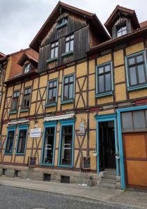 ein altes Gebäude mit blauen Fenstern auf einer Straße in der Unterkunft Ferienwohnungen Bergstrasse in Wernigerode