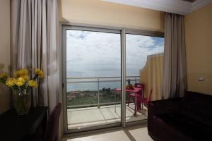 a living room with a large glass door to a balcony at Hotel Apartamentos Baia Brava in Gaula