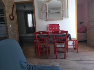 a room with two red chairs and a table at L Appicciu in Ventiseri