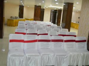 una fila de sillas blancas con relleno rojo y blanco en Hotel Galaxy, en Patna