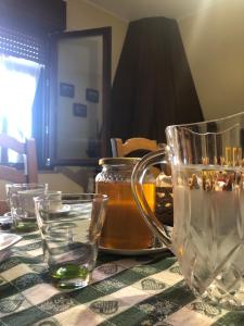 a table with a jar of honey and glasses on it at Domus Birdi in Orroli
