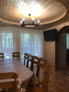 a dining room with a table and a chandelier at Ялинка in Migovo +82 photos