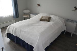 1 dormitorio con cama blanca y almohada en Idyllisk feriested, en Røyksund