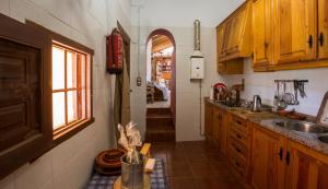 a kitchen with wooden cabinets and a sink and a window at Cortijo Los Nopales in Puerto Lumbreras