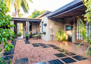 einen Hinterhof mit einer Terrasse und einem Haus in der Unterkunft Ama Zulu Guesthouse & Safaris in Hluhluwe