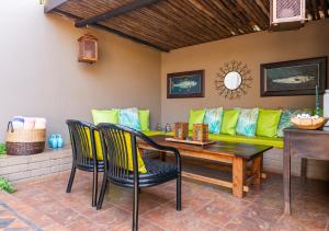 sala de estar con sofá amarillo y mesa de madera en Ama Zulu Guesthouse & Safaris en Hluhluwe