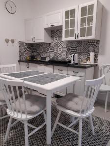 een keuken met een witte tafel en 2 witte stoelen bij u Skiby in Krajno Pierwsze