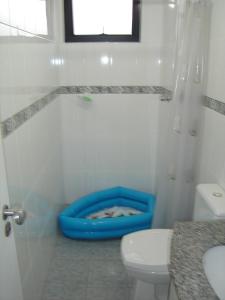 bagno con servizi igienici e vasca blu di Rosana a Praia Grande