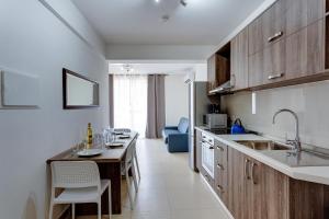 una cucina con armadi in legno e tavolo con sedie di Harmony Apartments a Msida