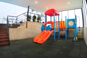 a playground with a slide in a room with a staircase at Aviary Bintaro in Serpong