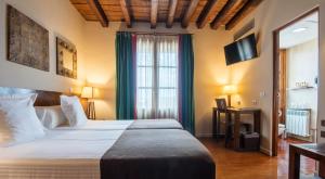 1 dormitorio con 1 cama grande y TV en Abad Toledo, en Toledo