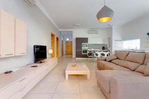a living room with a couch and a tv at Apartment In Fort Cambridge with Pool in Sliema