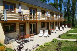 a house with chairs and a deck and a balcony at Le Relais du Hibou in Vittefleur