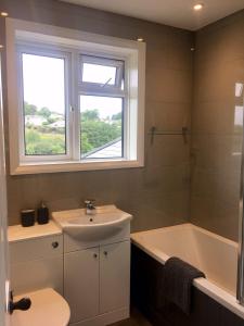 a bathroom with a sink and a tub and a window at The Cornish Retreat in Bude +20 photos