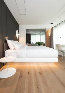 a living room with a white couch and white pillows at KPM Hotel & Residences in Berlin
