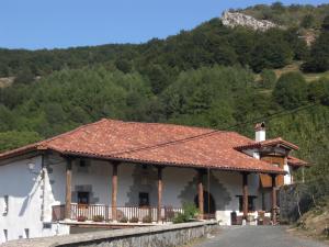 Odériz的住宿－艾特薩託鄉村民宿，路边有瓷砖屋顶的房子