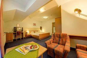 ein Hotelzimmer mit einem Bett und einem Wohnzimmer in der Unterkunft Hotel Flattacher Hof in Flattach