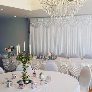 een kamer met witte tafels, witte stoelen en een kroonluchter bij Brewers Lodge in Blackwood