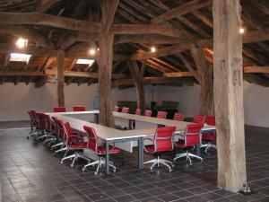 uma sala de conferências com uma mesa longa e cadeiras vermelhas em Etxatoa em Odériz