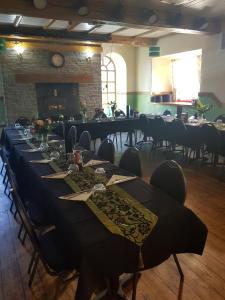 a long table in a room with tables and chairs at Brewers Lodge in Blackwood