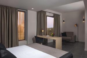 ein Hotelzimmer mit einem Bett und einem Tisch und Stühlen in der Unterkunft Azur Suites in Athen