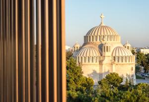 ein großes Gebäude mit einem Kreuz darüber in der Unterkunft Azur Suites in Athen