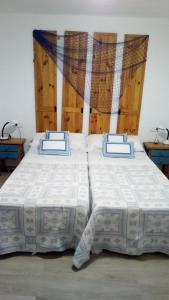 - une chambre avec 2 lits dotés d'oreillers bleus et blancs dans l'établissement PILARSEVAHOME-APARTAMENTO MARINERO, à Santa Pola