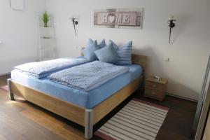 a bedroom with a bed with blue pillows at Haus Morgensonne in Weilheim