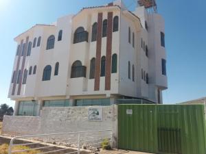 a building with a green gate in front of it at Hostal Campestre Casa Blanca in Chucuito +25 photos