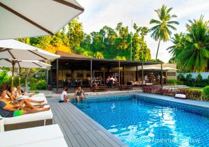 eine Gruppe von Menschen, die um einen Pool herum sitzen in der Unterkunft Meridian Adventure Marina Club & Resort in Saonek