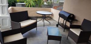 a patio with chairs and a table and a grill at La casa Mia guesthouse in La Gaulette