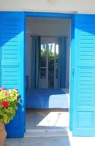 a blue room with a bed and a window at Galanis Place in Antiparos